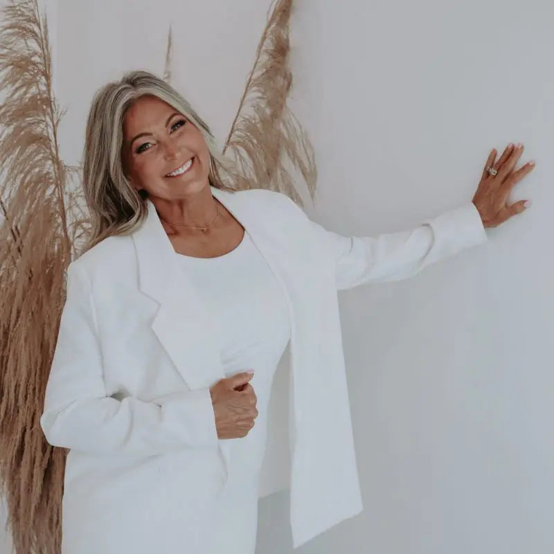 Mandy, founder of JMT Sunless, smiling in a white blazer